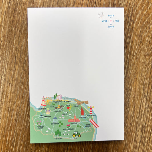 Notepad with a coluorful North Norfolk map design on a wooden surface