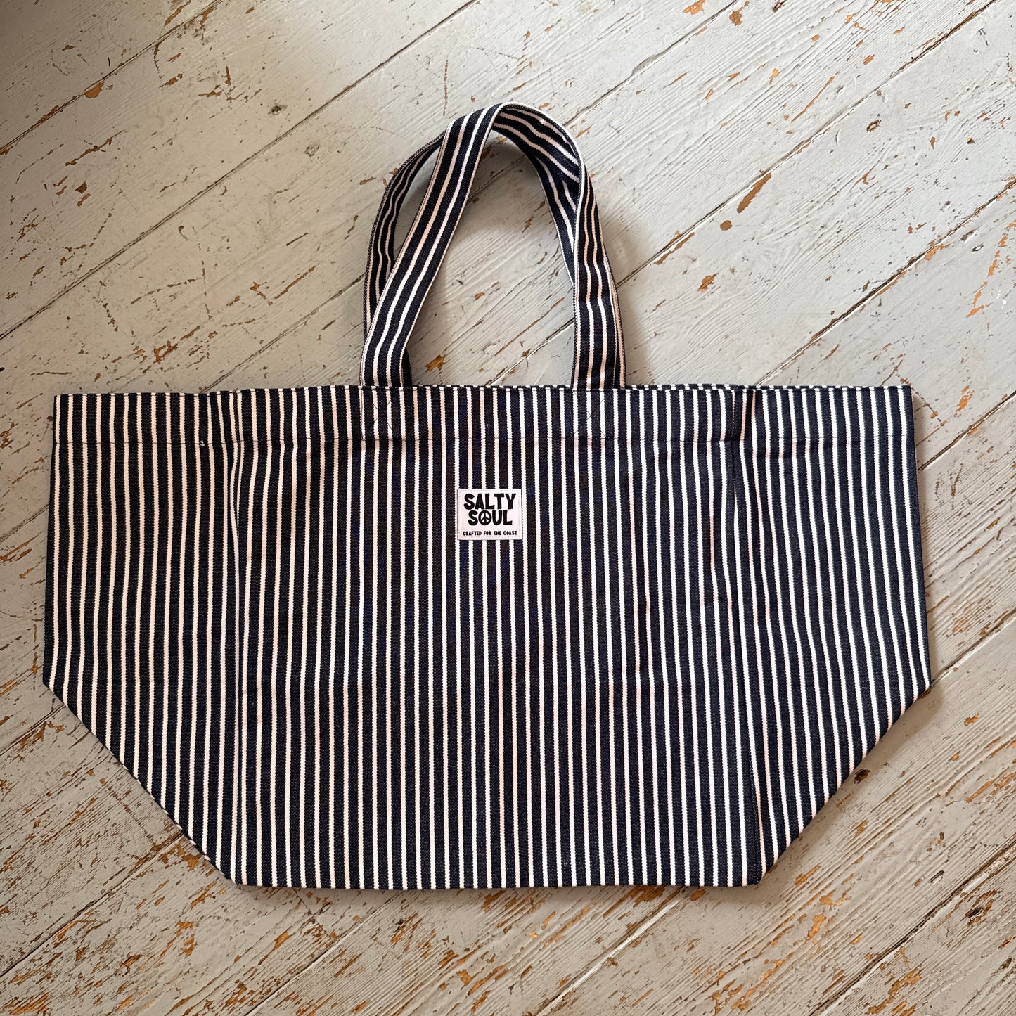flat lay of striped salty soul tote on a wooden floor
