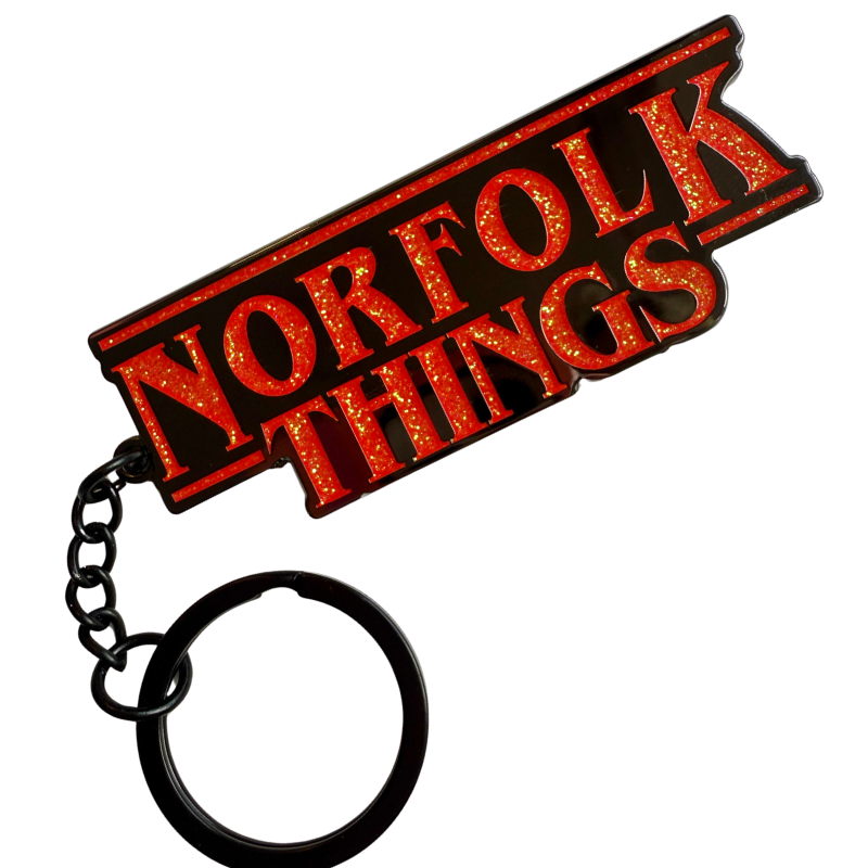 Black Keychain with red glitter 'Norfolk Things' text on a white background