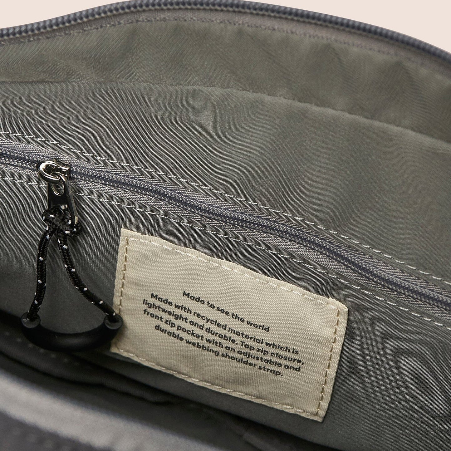 Gray bag with a label on a beige background
