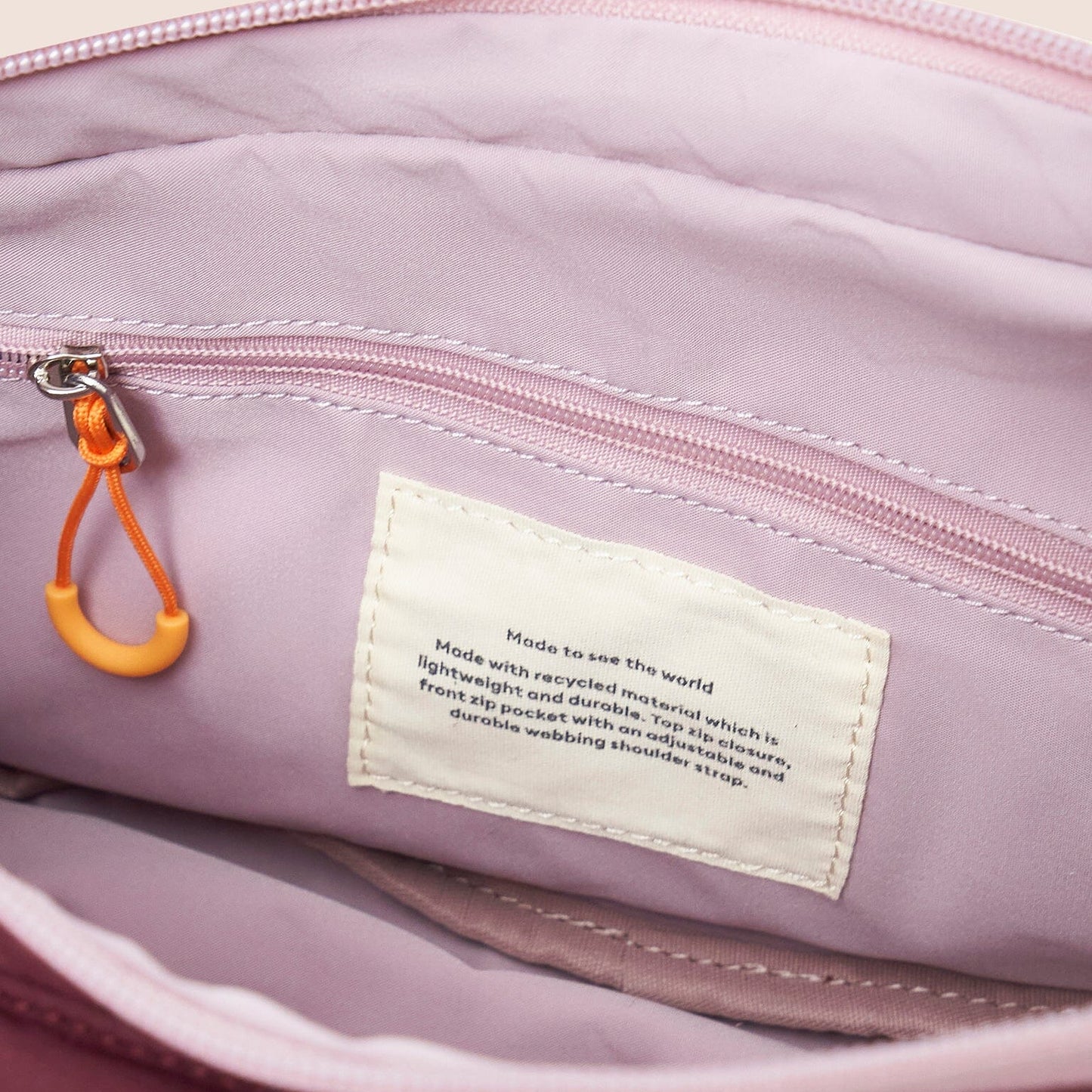 Gandys sling shoulder bag with a visible brand label on a beige background