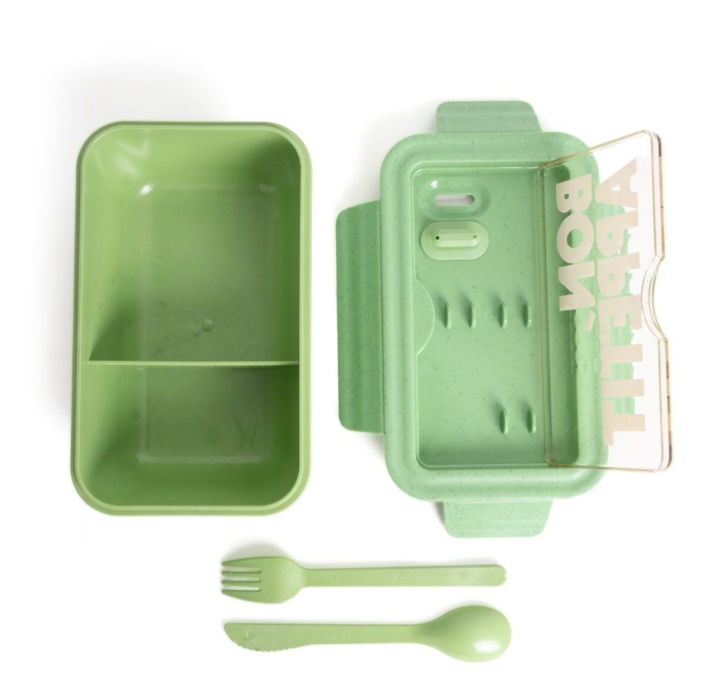 green reusable bento lunch box with matching knife and folk inside, eco friendly food container on a white background