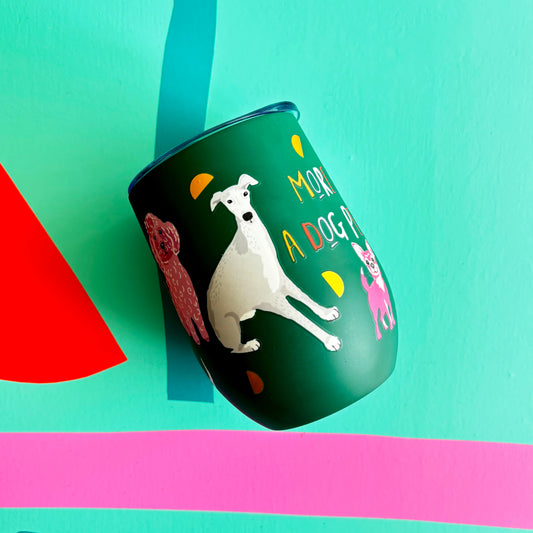 Hand holding a green thermal tumbler with greyhound dog illustration 'more of a dog person' text against a teal background