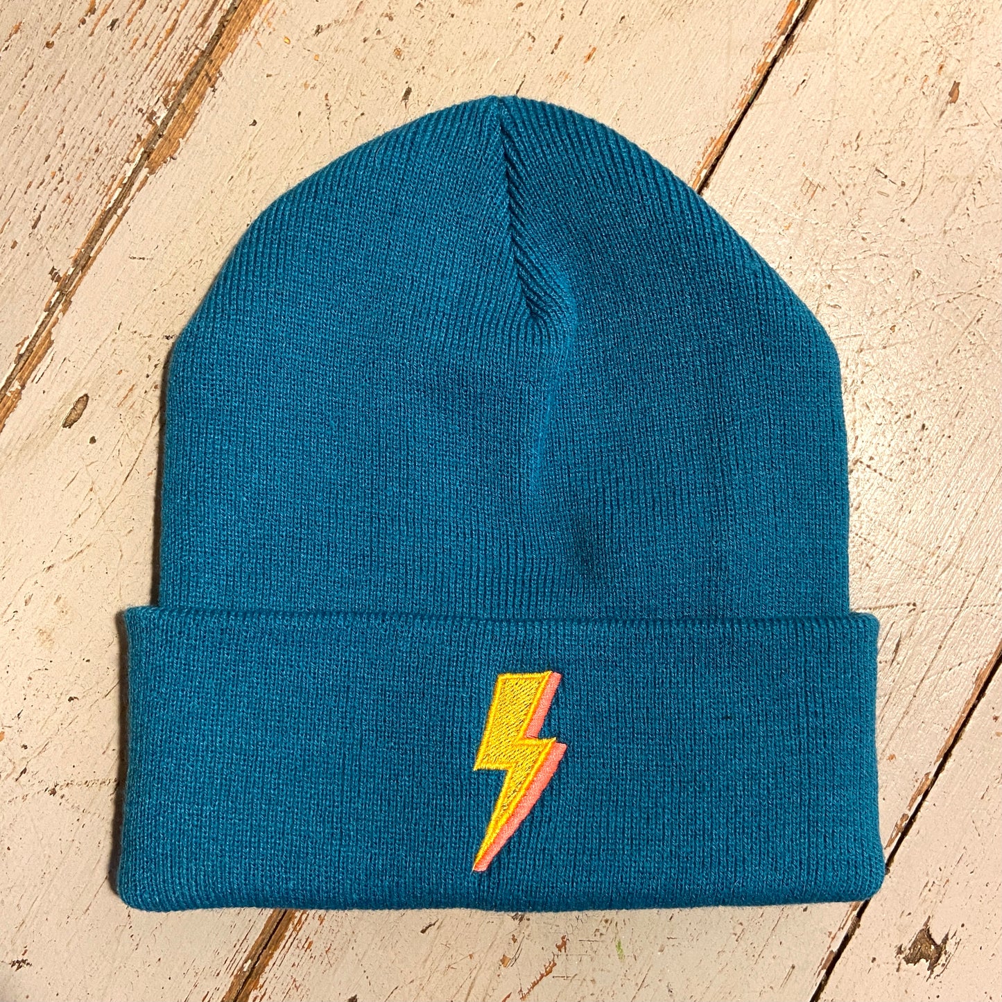 Embroidered to match our ever popular lighting bolt design. Available in Teal or black Beanies are made from 100% soft-touch acrylic in a double layer knit. One size fits all. Glitter & Mud