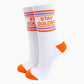 White socks with orange accents and Harry Styles 'Stay Golden' text on a white background