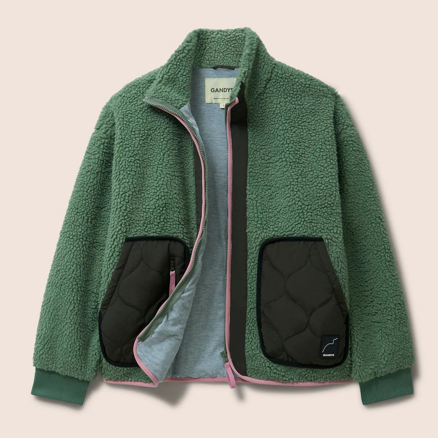 Gandys Green fleece jacket with quilted black pockets on a beige background