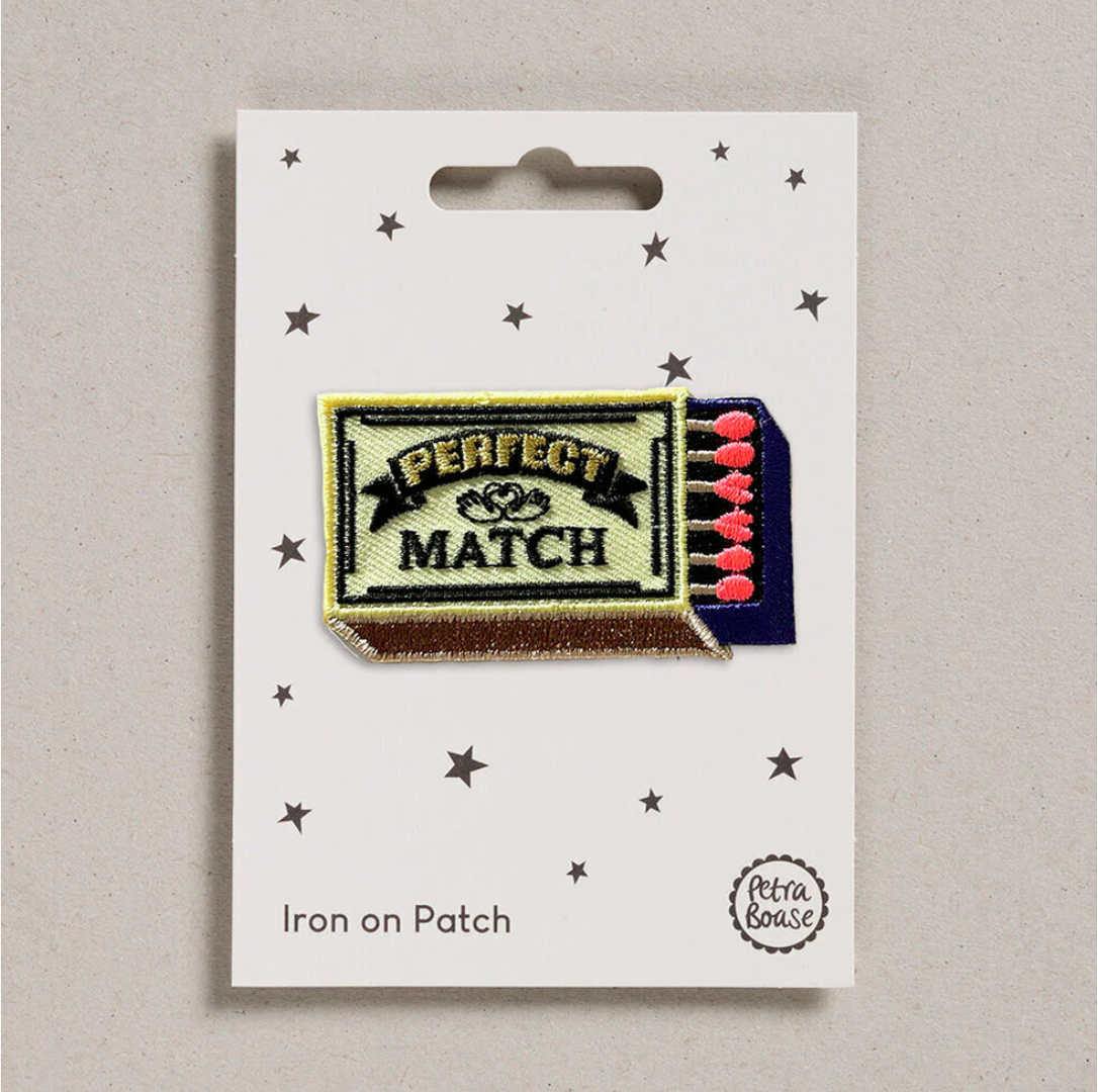 Embroidered iron on 'Perfect Match' yellow Match box patch, on a white card with black stars and 'Petra Boase' Branding 