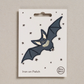 Embroidered iron on Flying bat patch, on a white card with black stars and 'Petra Boase' Branding 
