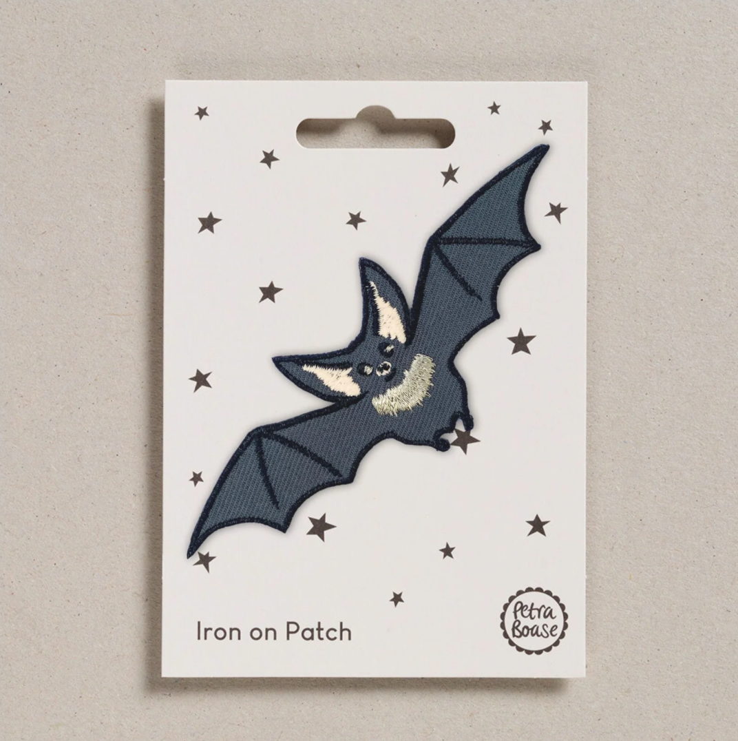 Embroidered iron on Flying bat patch, on a white card with black stars and 'Petra Boase' Branding 