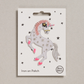 Embroidered iron on Sparkle unicorn  patch, on a white card with black stars and 'Petra Boase' Branding
