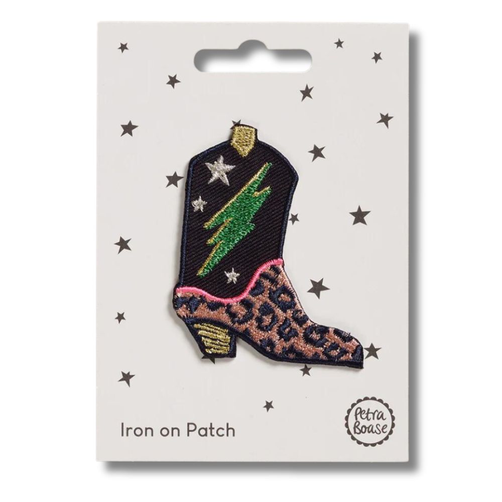 a cowboy boot iron on patch with multicolored and leopard print embroidered detailing with a green bolt and stars on a white card with star graphics and 'petra boase' branding