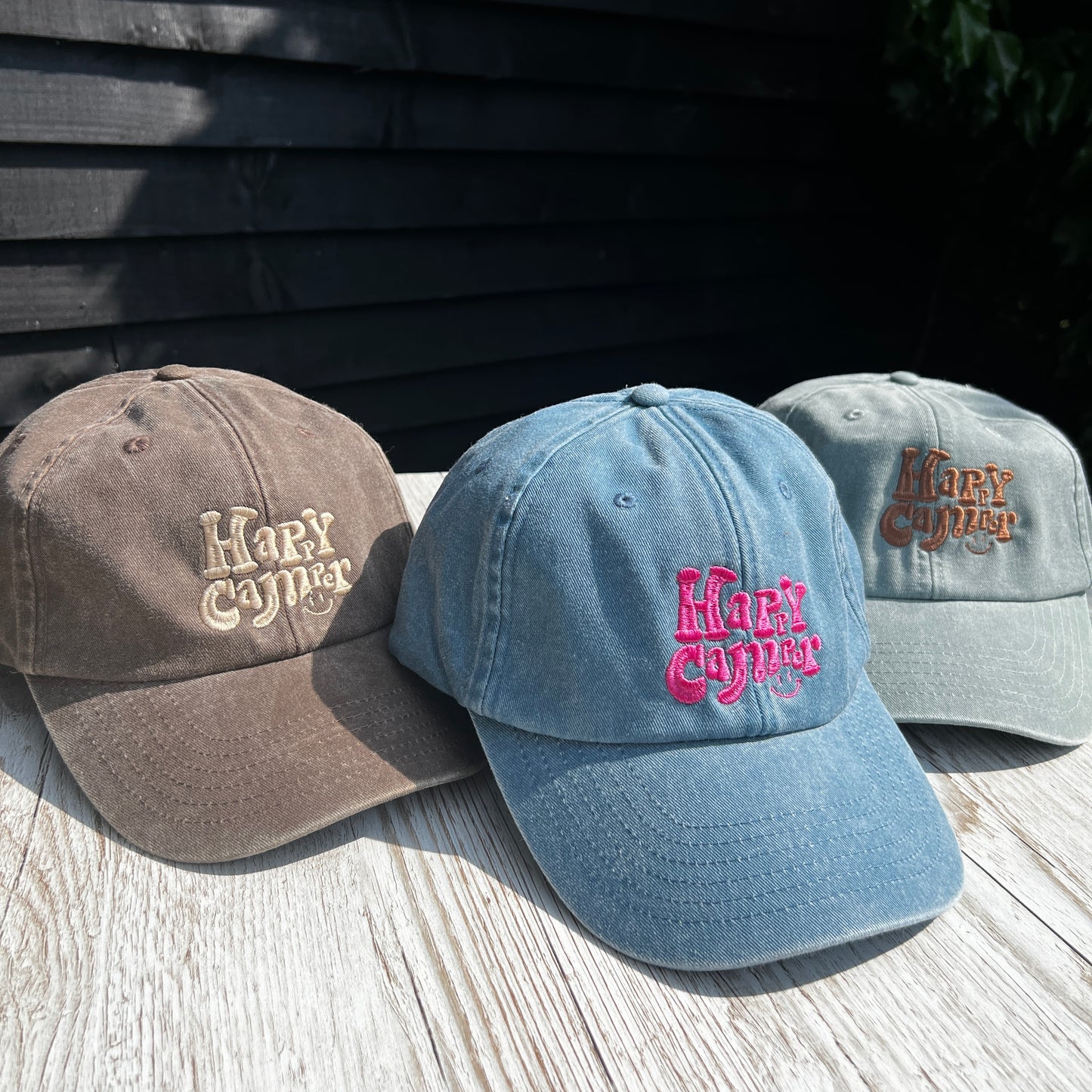 vintage style Happy camper embroidered washed dad cap on a light wooden surface 