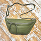 Khaki green XL leather bum bag with silver hardwear on a wooden surface 