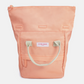 A peach-pink canvas tote bag with light beige fabric handles and a white brand label reading 'KIND BAG'.