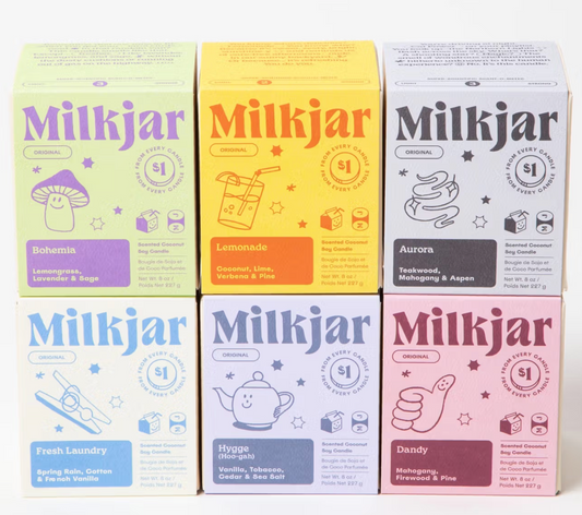 six milk jar candles in boxes stacked together. colourful boxes scented coconut soy wax. 