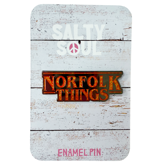 Red Glitter Enamel pin with 'Norfolk Things' text on a wooden texture card with 'Salty Soul' branding.