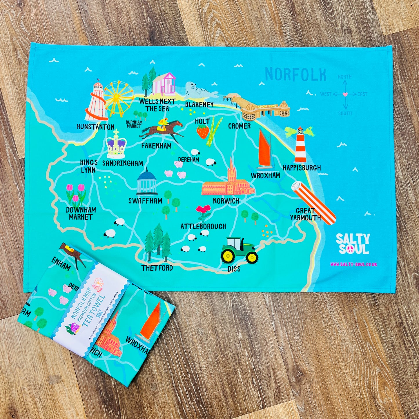 Colourful map of North Norfolk coast on a wooden surface with 'Salty Soul' branding.
