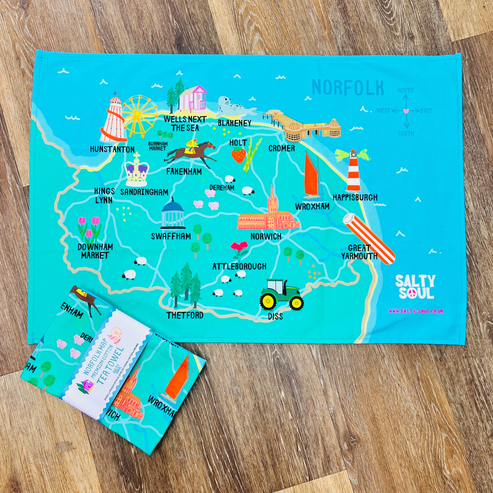 Colourful map of North Norfolk coast on a wooden surface with 'Salty Soul' branding.
