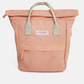 A peach-colored roll-top canvas tote bag with light beige webbed handles and a white brand label reading 'KIND BAG' on the front.