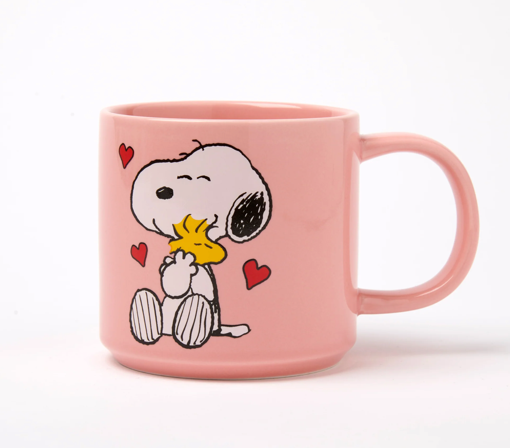 pastel Pink mug with Snoopy and Woodstock hugging surrounded by love hearts design on a white background