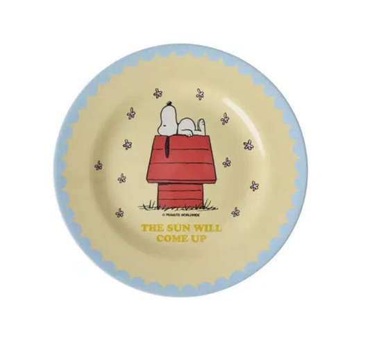 Snoopy pale yellow melamine plate with cartoon snoopy on top of a red dog house. the plate has a scallop blue edge n a white background.