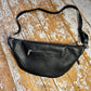 XL black bum bag back showing small silver zip and detachable strap, on a wooden background 