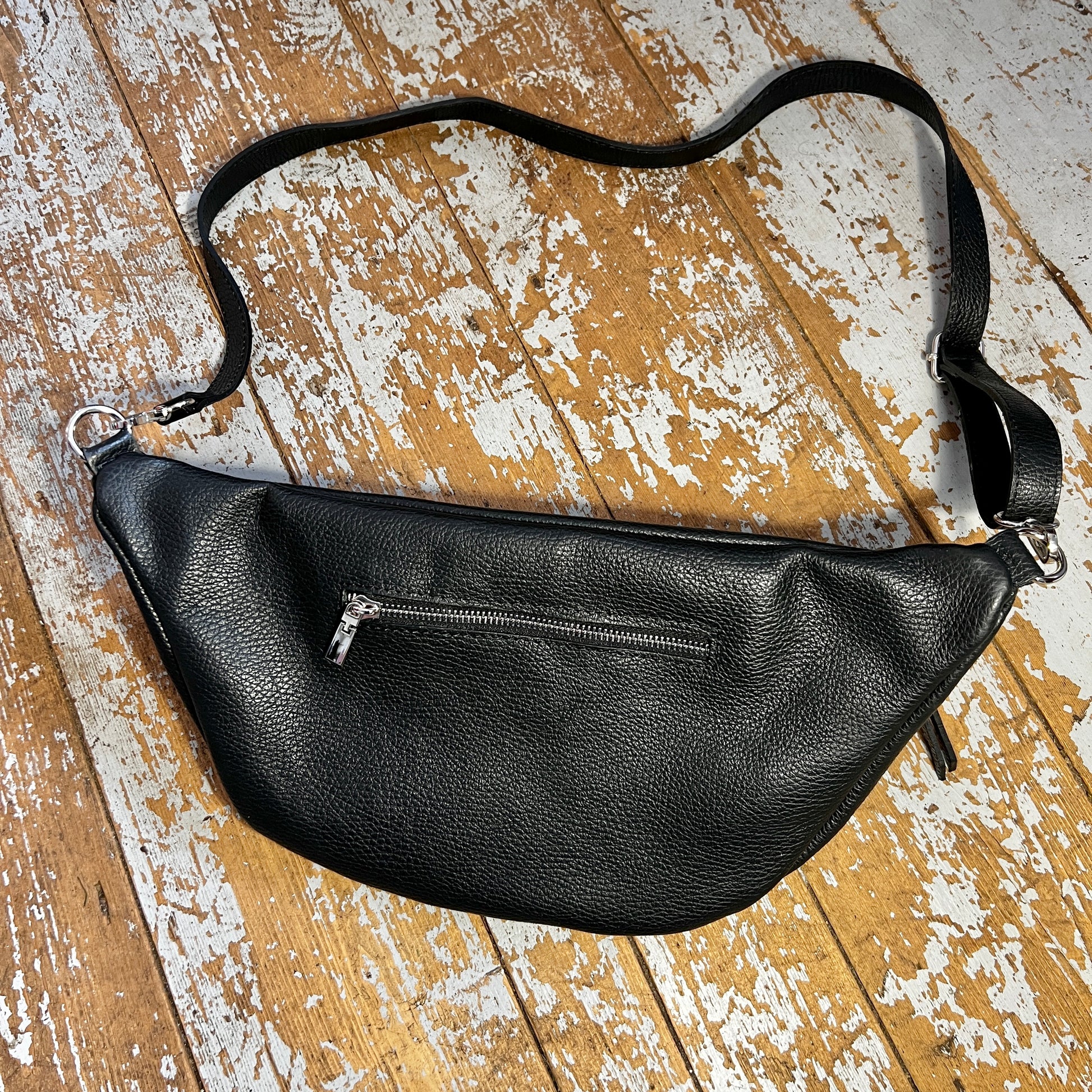 XL black bum bag back showing small silver zip and detachable strap, on a wooden background 