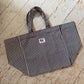Large black and white striped tote bag with a white salty soul label on the front, on a wooden floor.