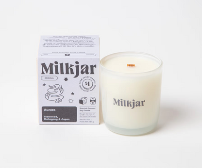 Aurora milkjar candle in clear jar next grey to packaging box with graphics and scent 'teakwood mahogany and aspen' wooden crackle wick. Plant-based coconut soy wax 40–45 hour burn time with proper wick trimming Vegan and cruelty-free