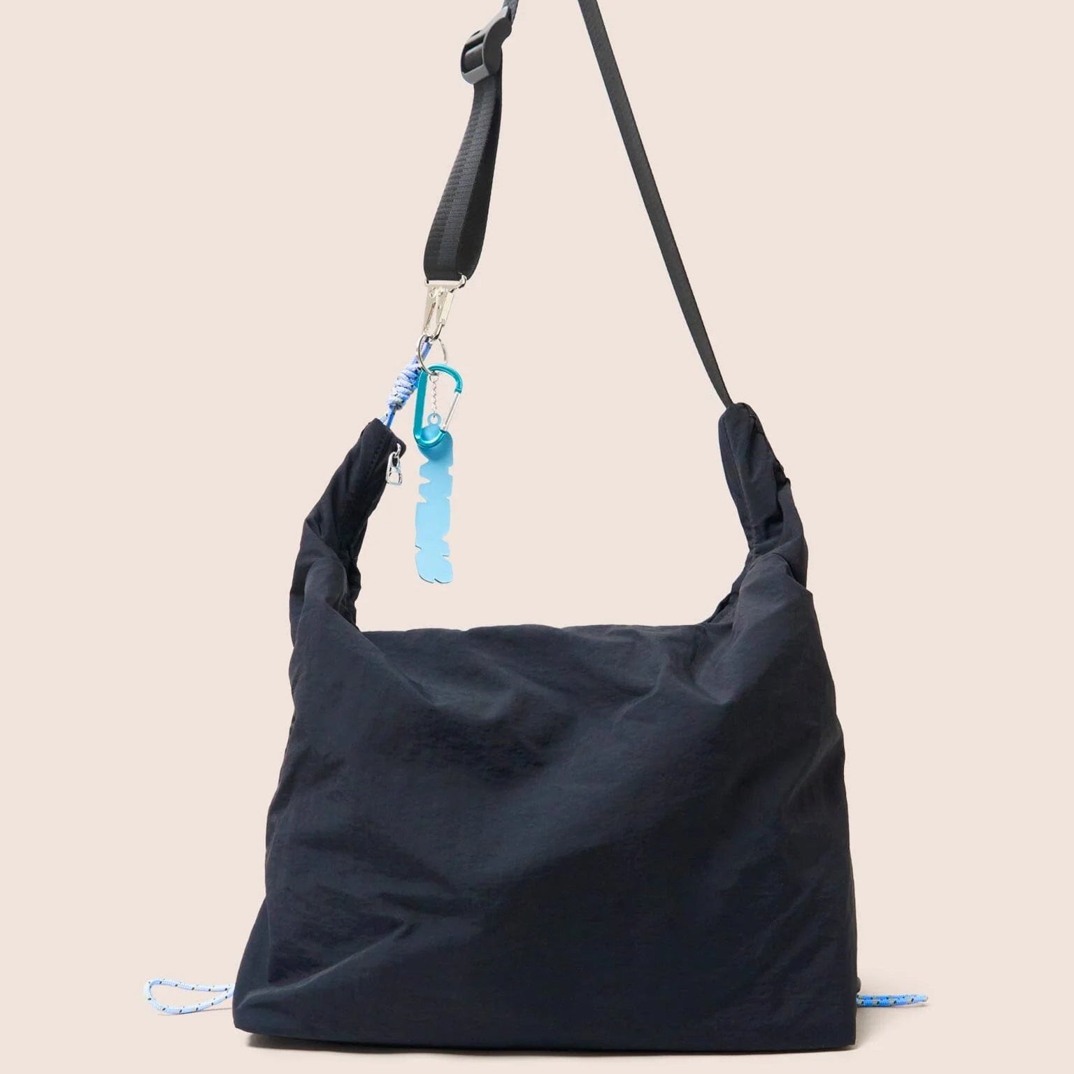 Gandys black shoulder bag with a blue tag on a beige background