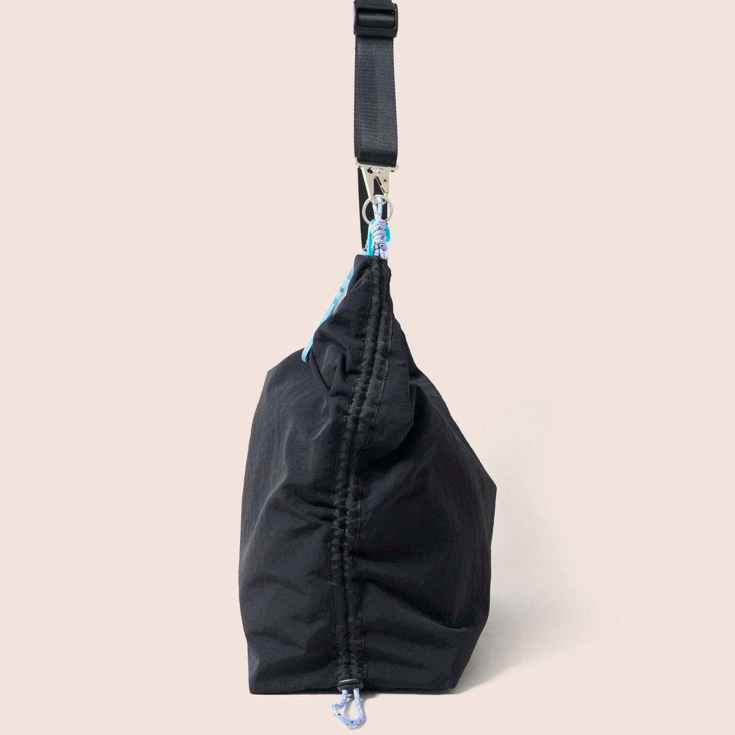 Gandys black bag with a strap on a beige background