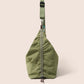 Gandys Green sling bag with a strap on a beige background