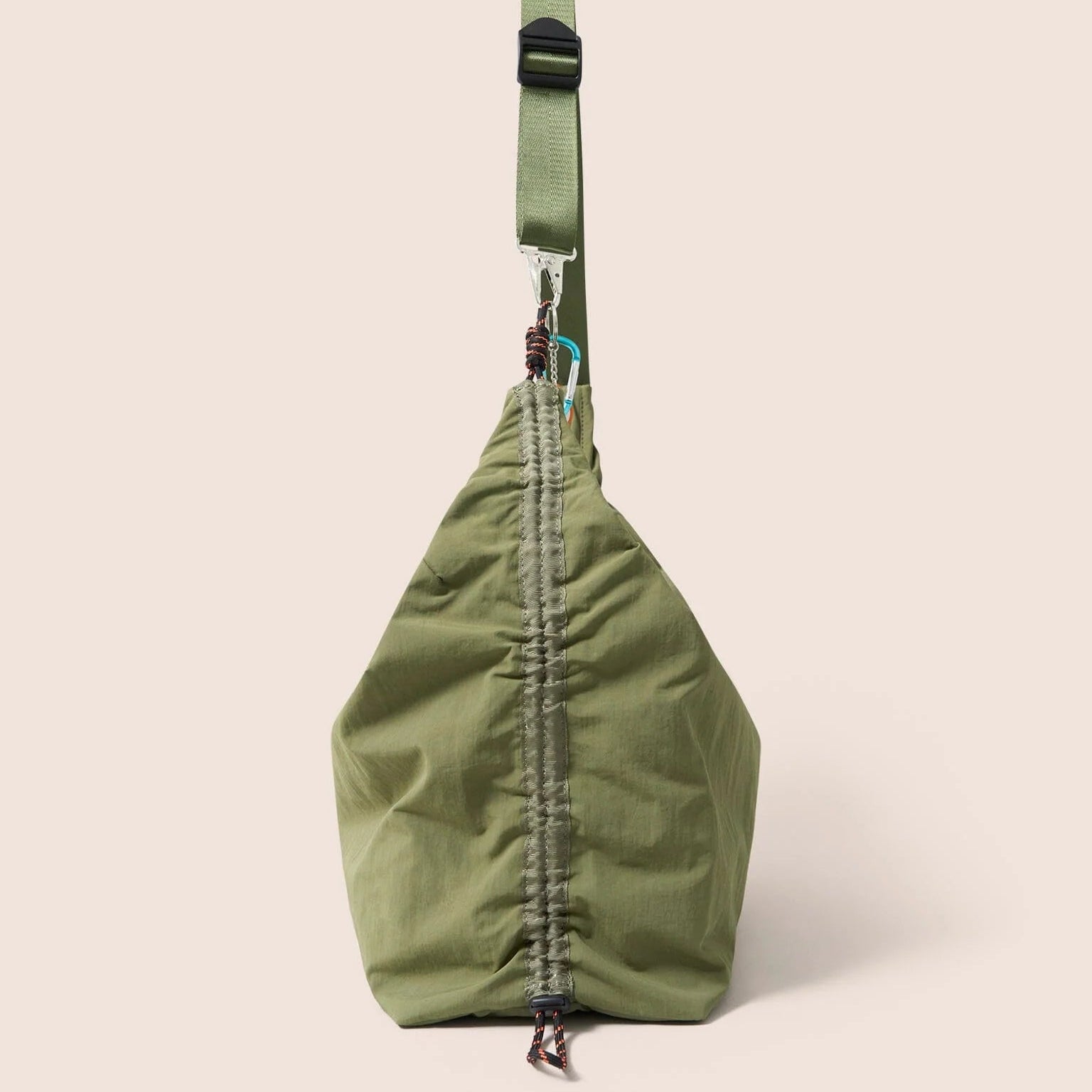 Gandys Green sling bag with a strap on a beige background
