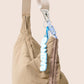 Gandys taupe bag with a blue and white carabiner attached on a beige background
