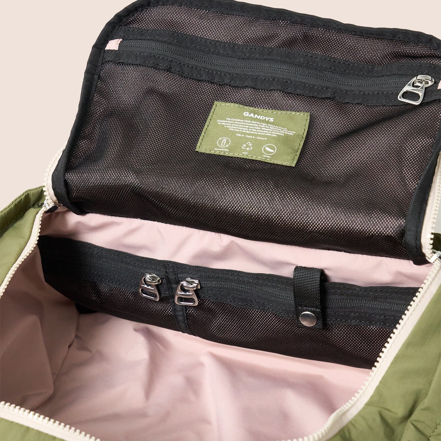 Green bag with a black interior and a visible brand label on a beige background
