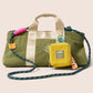 Green duffel bag with a yellow pouch and colorful strap on a beige background