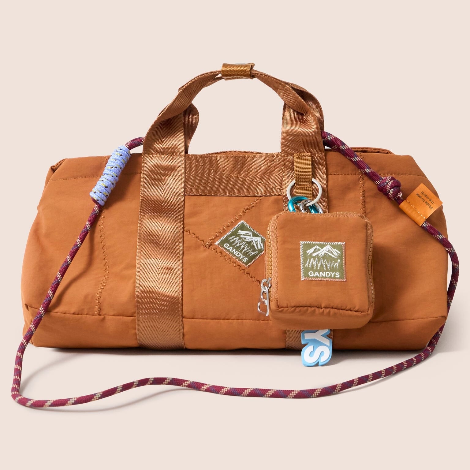 Gandys orange cube bag with a attached pouch on a beige background