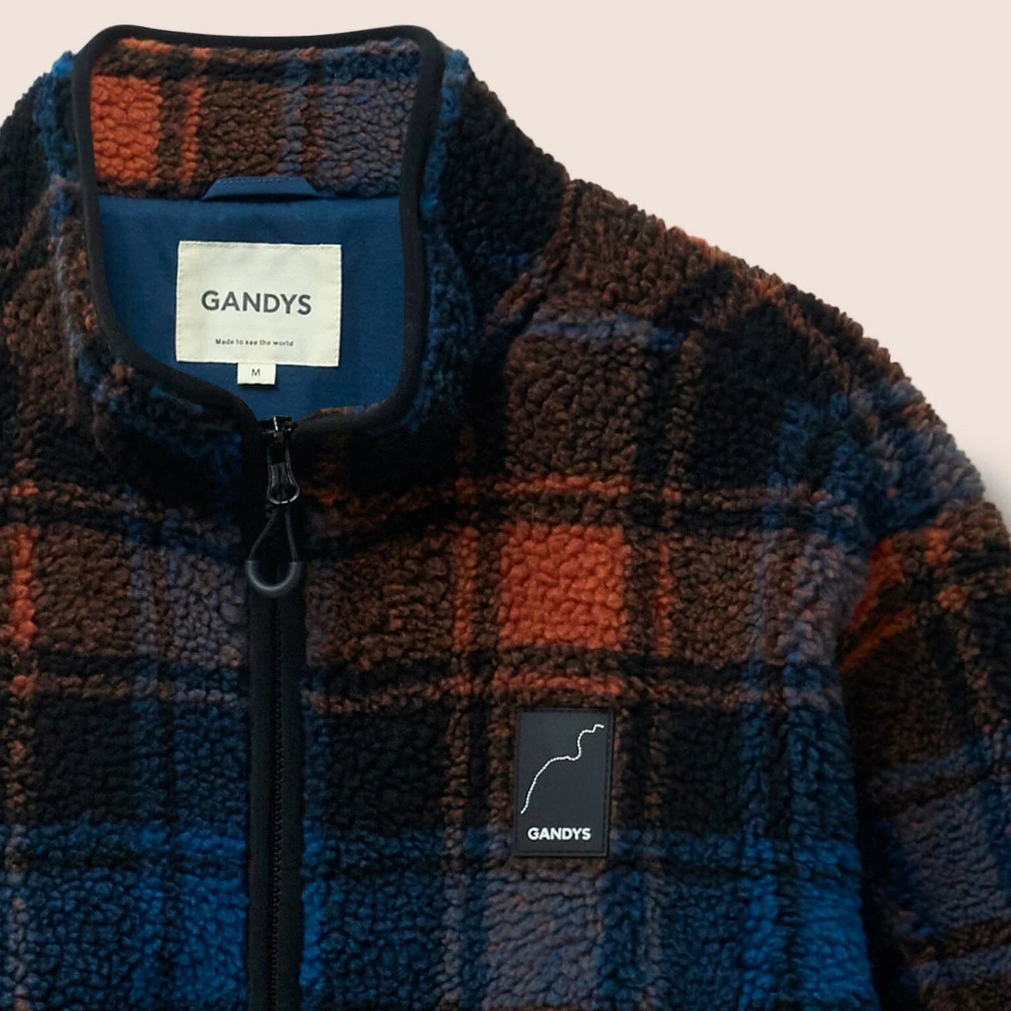 Plaid jacket with visible 'GANDYS' branding on a beige background