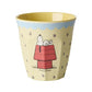 Yellow cup with Snoopy design on red dog house with blue trim around the top of the cup on a white background