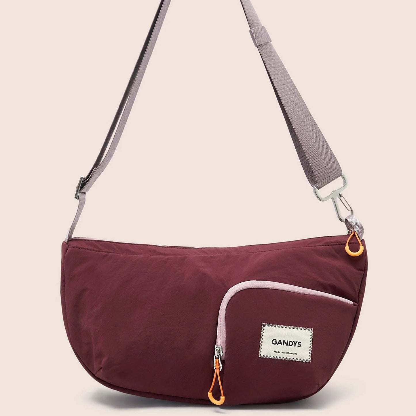Gandys sling shoulder bag with a visible brand label on a beige background
