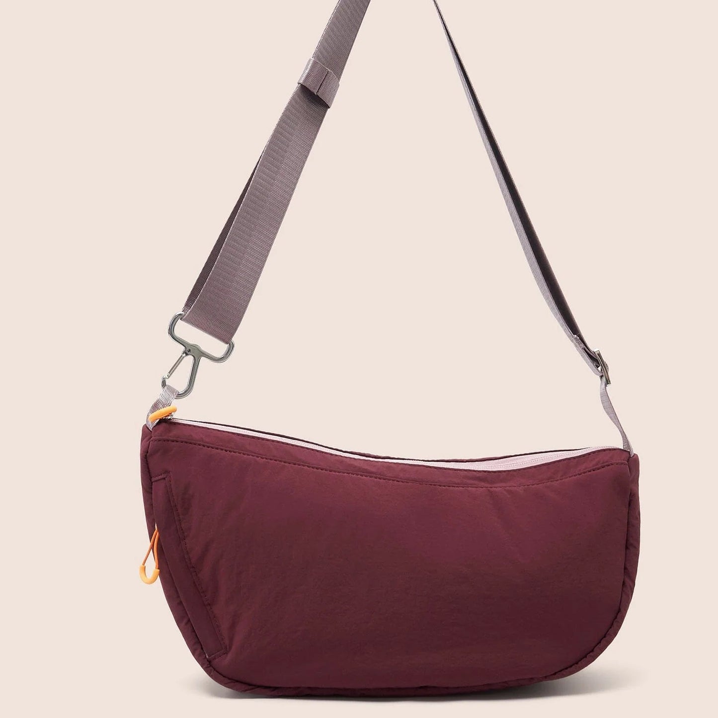 Gandys sling shoulder bag with a visible brand label on a beige background