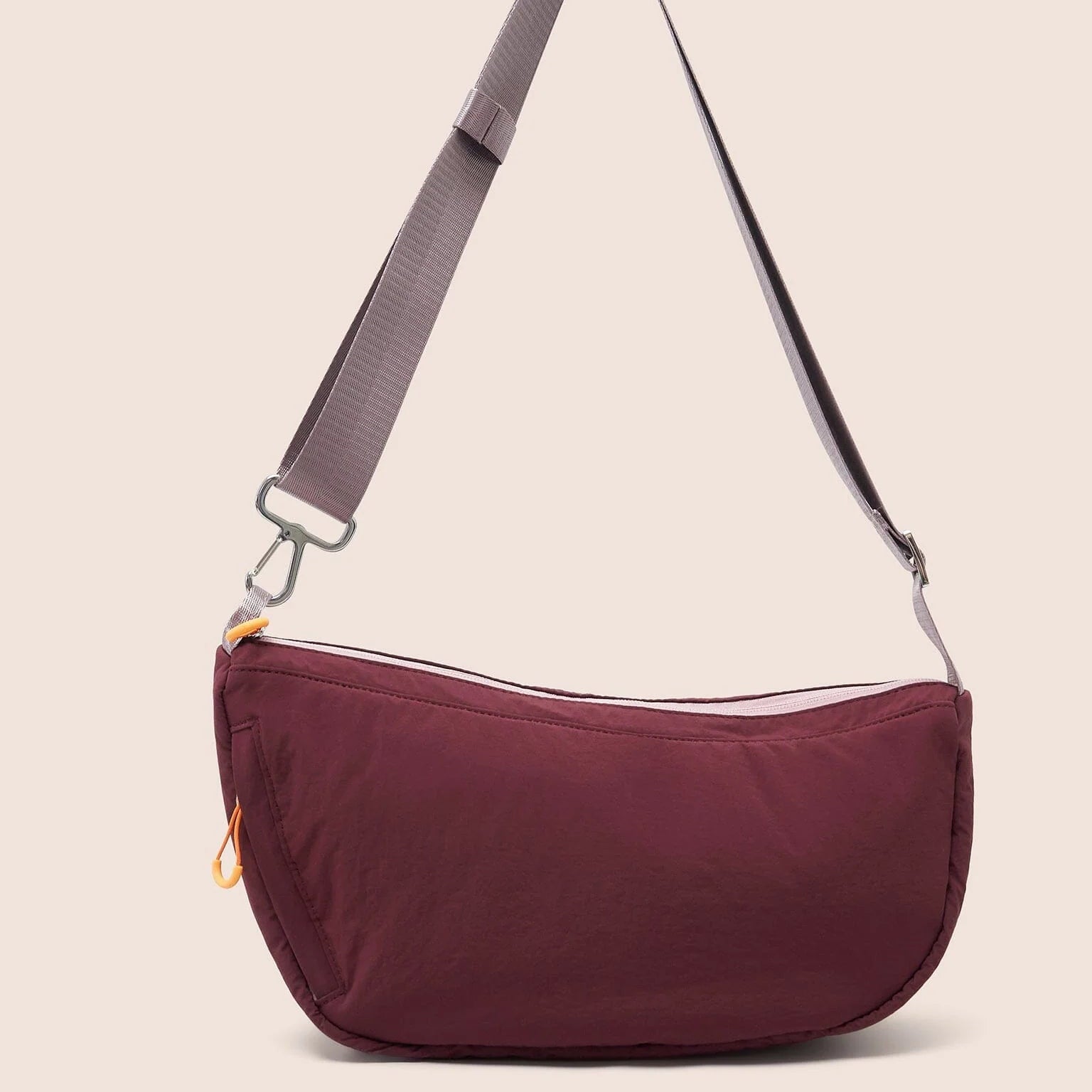 Gandys sling shoulder bag with a visible brand label on a beige background