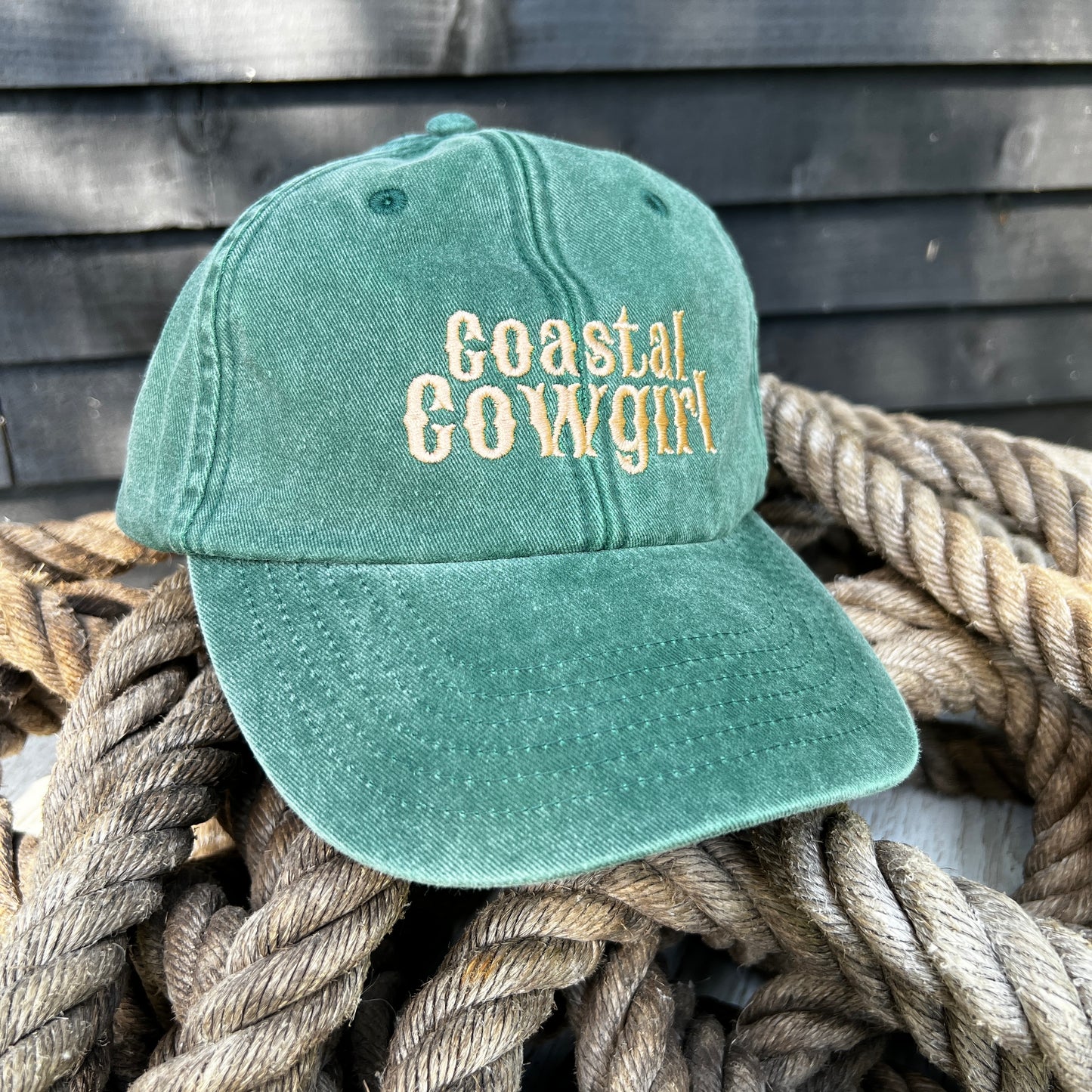 green coastal cowgirl Embroidered dad cap on a pile of ropes 