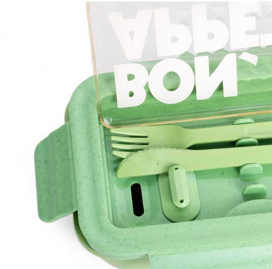 Green plastic cutlery set with clear lid on a white background