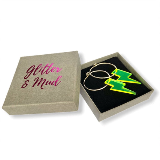A little  pop, with a flash of a neon lightning bolt earring is fun statement to brighten the blackest of dresses.  Made by us from silver wire & fashioned into hoops with  a neon lightning bolt pop. Glitter and Mud