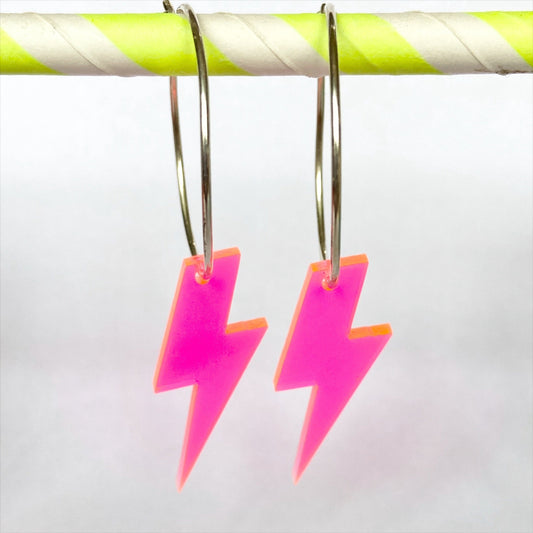 A little  pop, with a flash of a neon lightning bolt earring is fun statement to brighten the blackest of dresses.  Made by us from silver wire & fashioned into hoops with  a neon lightning bolt pop. Glitter and mud