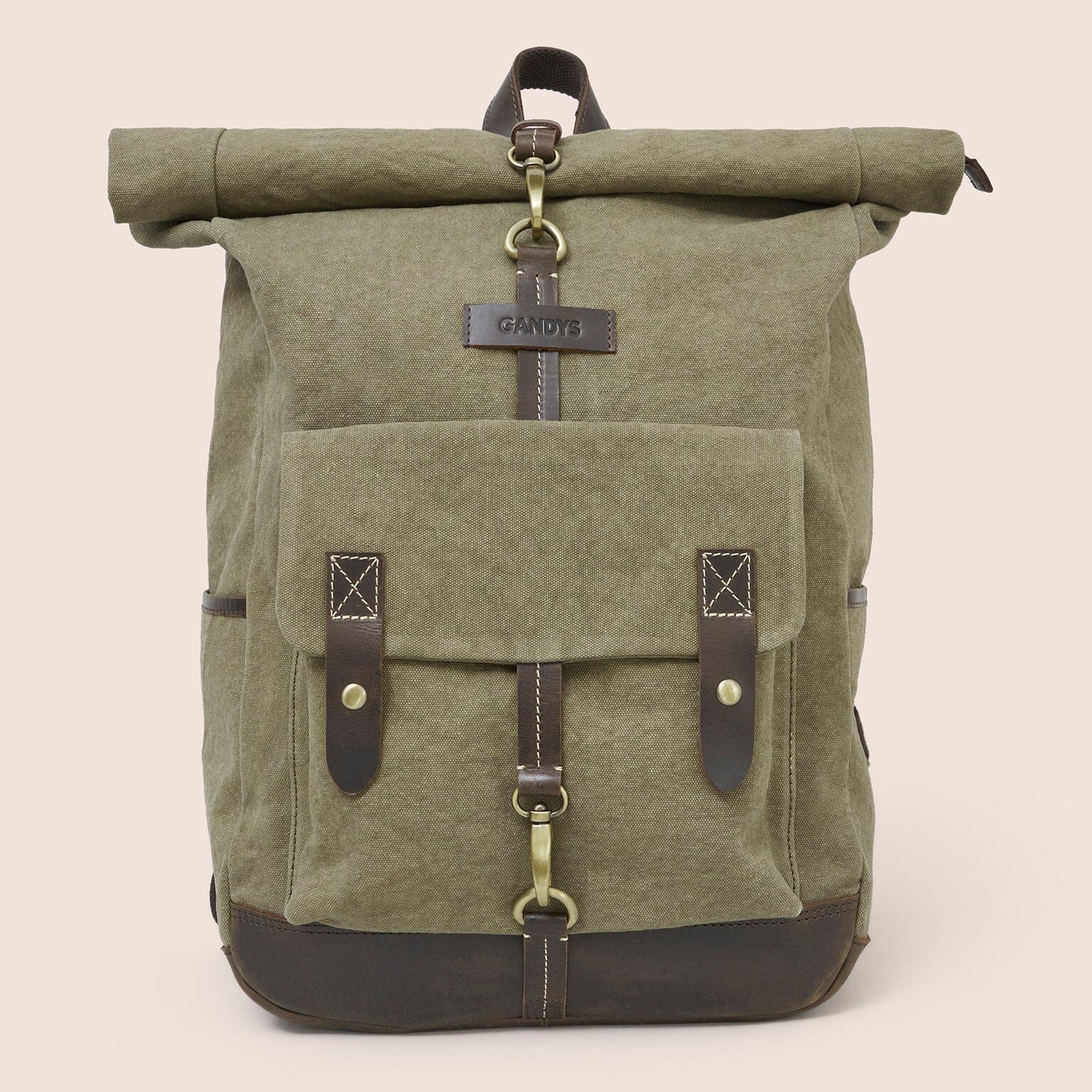 Green roll-top backpack with leather straps on a beige background