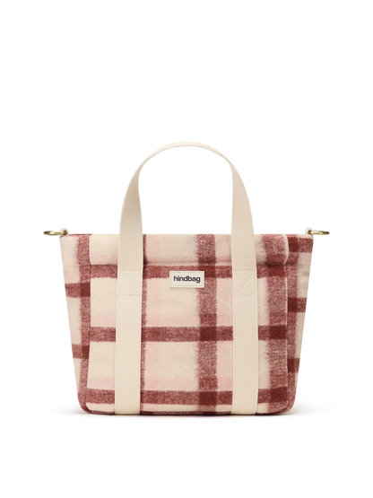 A small tote bag with a dusty pink and rust red plaid pattern, featuring cream-colored fabric handles and a small white 'hindbag' brand label on the front.