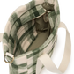 A green and cream plaid fleece shoulder bag with a wide cream fabric strap and gold-tone metal hardware, shown from an overhead angle on a white background.