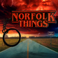 Road leading into a stormy horizon with 'Norfolk Things' glitter text and a keychain.